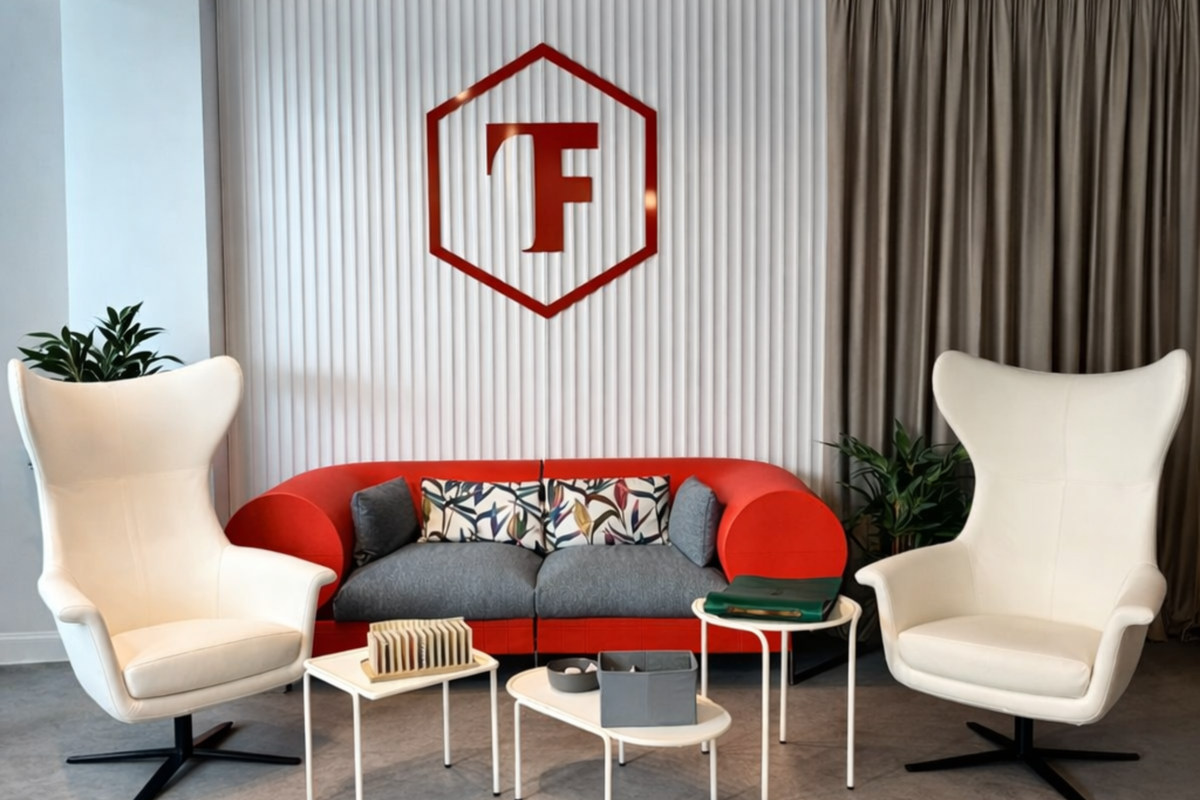 Showroom Trend Furniture București – zonă lounge cu logo și canapea roșie